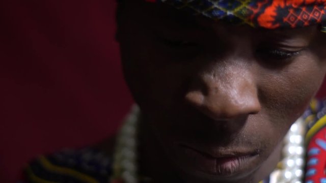 Serious man in dashiki and a bright bandana looks at the camera