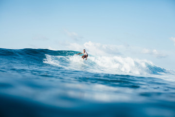handsome athletic man surfing on ocean wave - obrazy, fototapety, plakaty