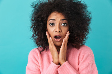 Colorful image closeup of surprised woman grabbing face with excited look and open mouth, isolated over blue background