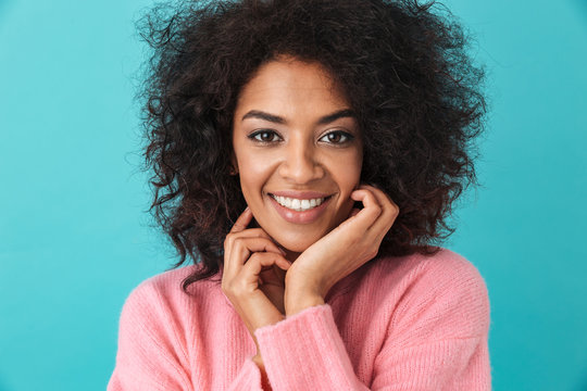 Multicolor image of pretty woman 20s with afro hairstyle smiling on camera with perfect white teeth, isolated over blue background