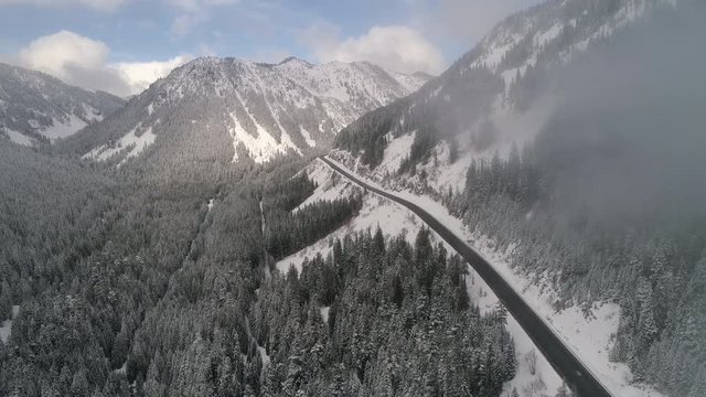 Aerial Cloud Reveal of Snowy Mountain Highway Road Trip