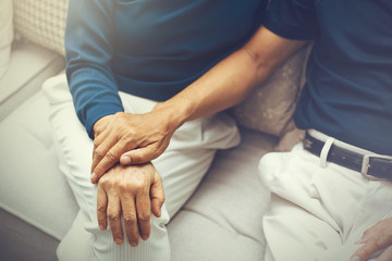 Close up shot of elderly senior couple holding hands and supporting with each other