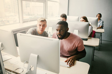 Group of students look in computer. Study.