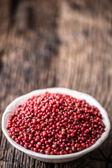 Red peppercorn in bowl on oak table