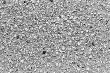 Concrete wall of the building with stones of different sizes. Abstract pattern of small, medium and large stones. Black and white image. Background, Wallpaper, backdrop or texture.