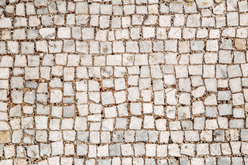 Stone pavement texture, abstract background of old cobblestone pavement close-up. Front view.