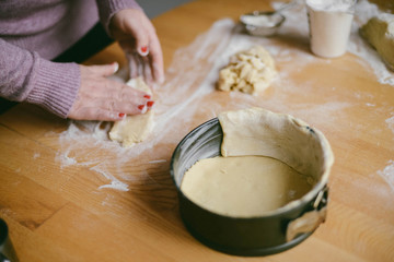 Ingredients for baking - flour, wooden spoon, rolling pin, eggs. Woman hands kneading fresh dough