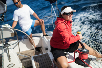 Attractive strong woman sailing with her boat