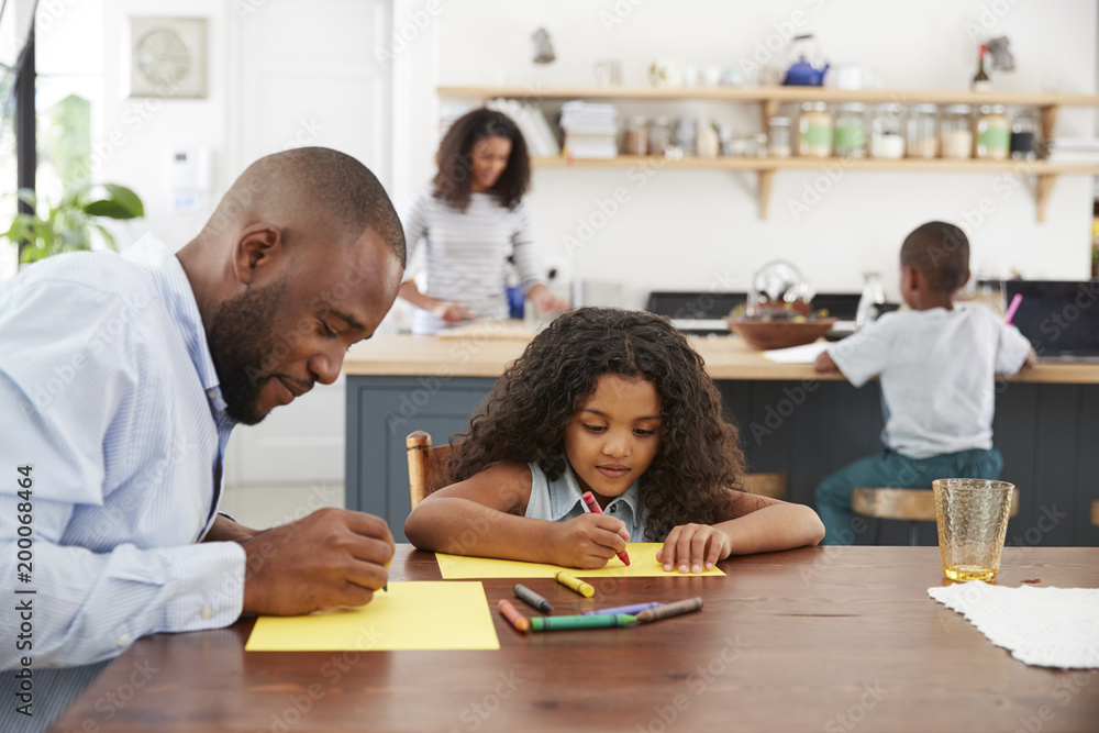 Wall mural Young black family of four busy in their kitchen, close up