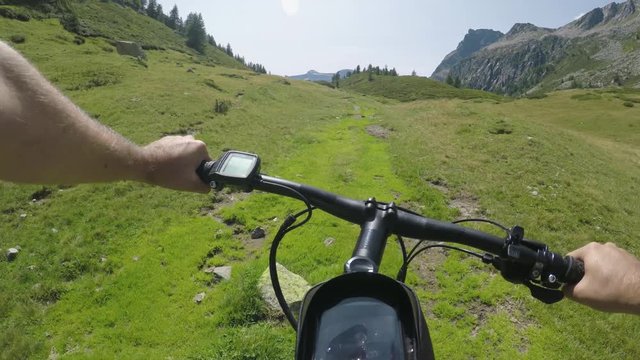 POV man riding e-bike on hill.Mtb action cyclist exploring trail path near mountains.Electrical bike active people sport travel vacation in Europe Italy Alps outdoors in summer.4k video