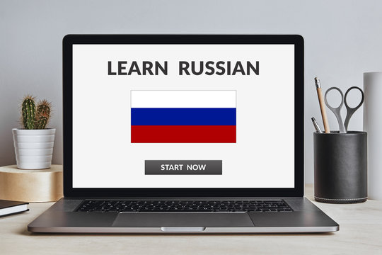 Learn Russian concept on laptop screen on modern desk. All screen content is designed by me. Front view.