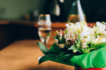 one bouquet staing on table in green pack with red tape