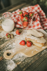 strawberry, fresh milk and sweet patties on a brown wood table