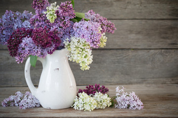 lilac in jug on old wooden background