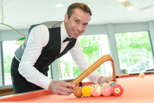 handsome man with suit sitting in billiard pool in club