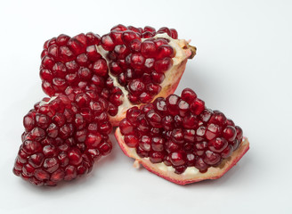 Part of delicious juicy ripe pomegranate and pomegranate seeds scattered around.