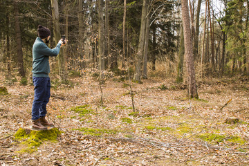 man taking photo with smartphone in the forest