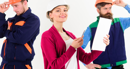 Team of architects, builders with woman manager,boss looks at document