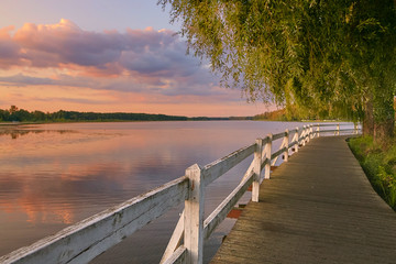 Wolsztyn, POLAND Picturesque wooden walkway along the lake shore at sunset.