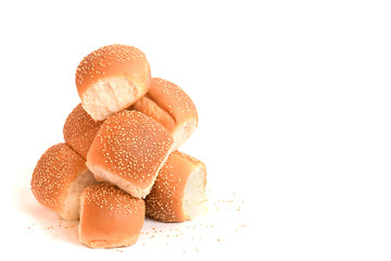 Seven buns with sesame seeds, stacked with a slide, on a white background