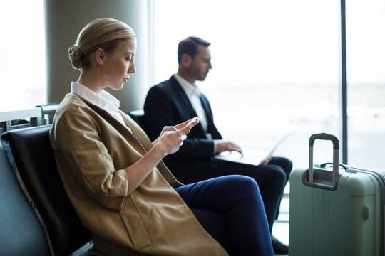 Woman using mobile phone in waiting area