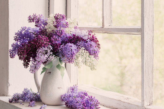 lilac in jug on old windowsill background