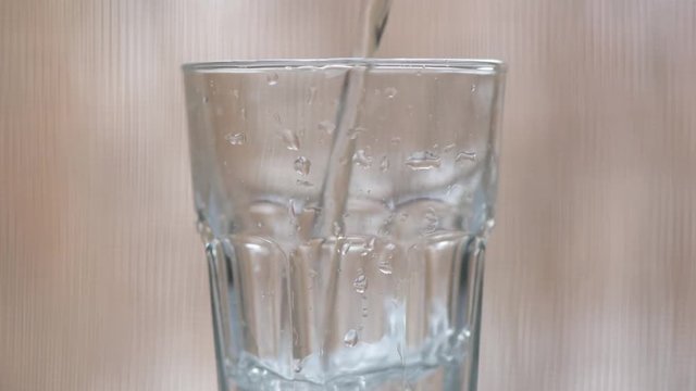 Pouring carbonated mineral water into drinking glass