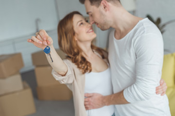 Fototapeta premium happy young couple holding key from new apartment and smiling each other