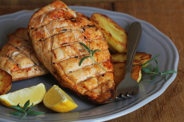 Grilled chicken breast with fried potato and lemon