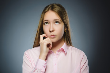 Closeup Thoughtful girl with Hand at head isolated on Gray