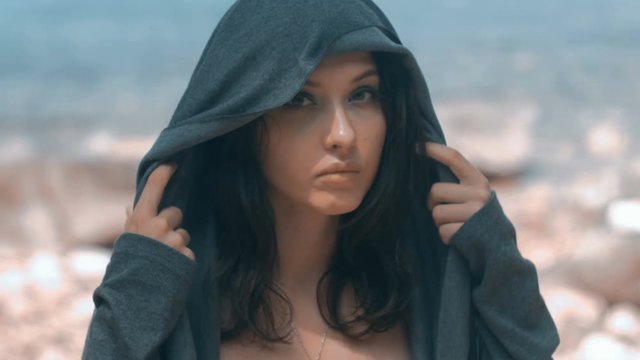 Mysterious beautiful woman with make up in grey hood