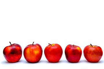 Five red apples in a row isolated on white background.