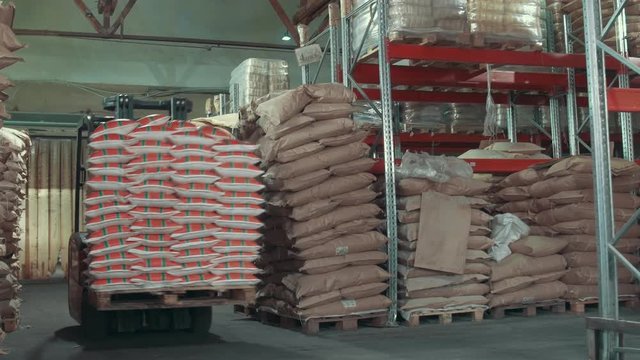 Red loaders transport pallet with boxes on industrial warehouse