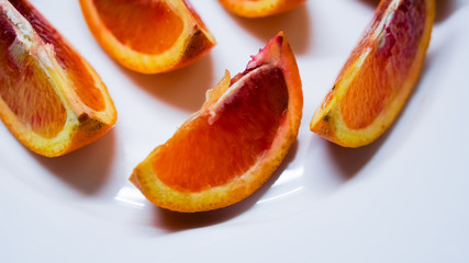 Fototapeta na wymiar pieces of blood orange on white plate
