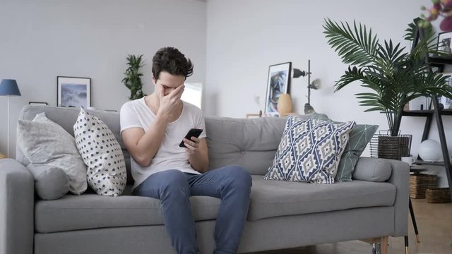 Tense Frustrated Man Reaction, while Using Smartphone