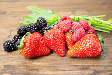 Strawberries and berries, a prelude of summer, placed on an old table. It is a good and fresh fruit that is very healthy and contains few sugars.