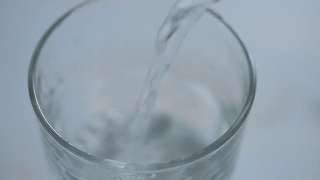 Pouring carbonated mineral water into drinking glass
