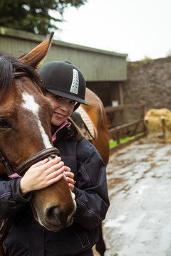 Pretty woman hugging her horse 
