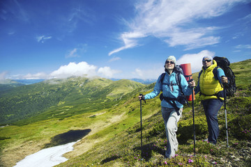 Summer hike in the mountains with a backpack and tent.