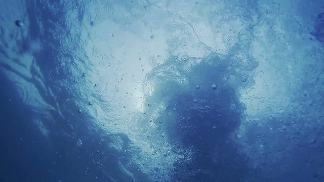Slow motion of male hand underwater, pov action camera shot of man drowning in blue sea water