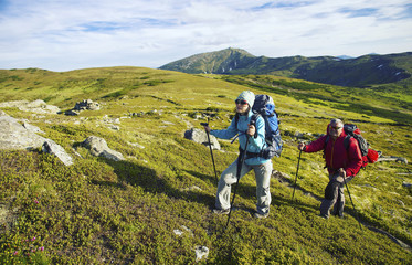Obraz premium Summer hike in the mountains with a backpack and tent.
