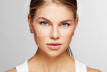 Fototapeta Skin care and technology. Portrait of beautiful woman face with drawn massage lines.  obraz