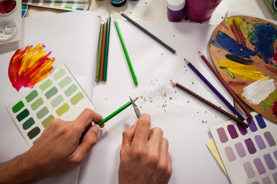 Man sharpening colored pencil in drawing class
