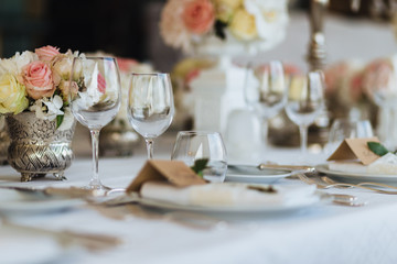 Beautiful table served with glassware and cultery, decorated with flowers, prepared for festive...