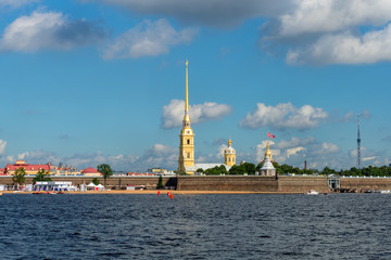 Naklejka premium RUSSIA, SAINT PETERSBURG - AUGUST 18, 2017: View on the Peter and Paul Fortress, the river Neva, the steeple with a cross, dome, sky, warm summer day, storm sky
