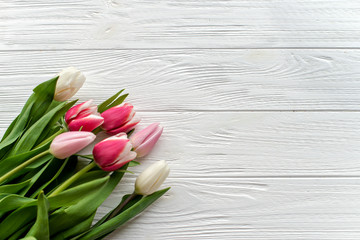 Obraz na płótnie Canvas Beautiful bouquet of multicolored tulips on a white wooden background on white wooden background. Copy space