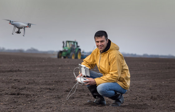 Farmer navigating drone above farmland