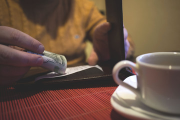 Fototapeta na wymiar a man sits in a cafe, pays cash in a cafe