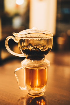 Brewing and draining the loose tea leaves in this easy to use stackable teapot. Selective focus.