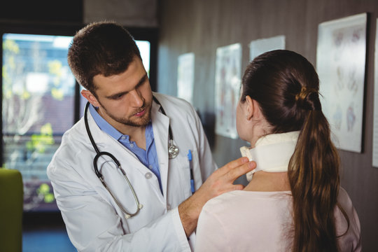 Physiotherapist examining a female patient's neck